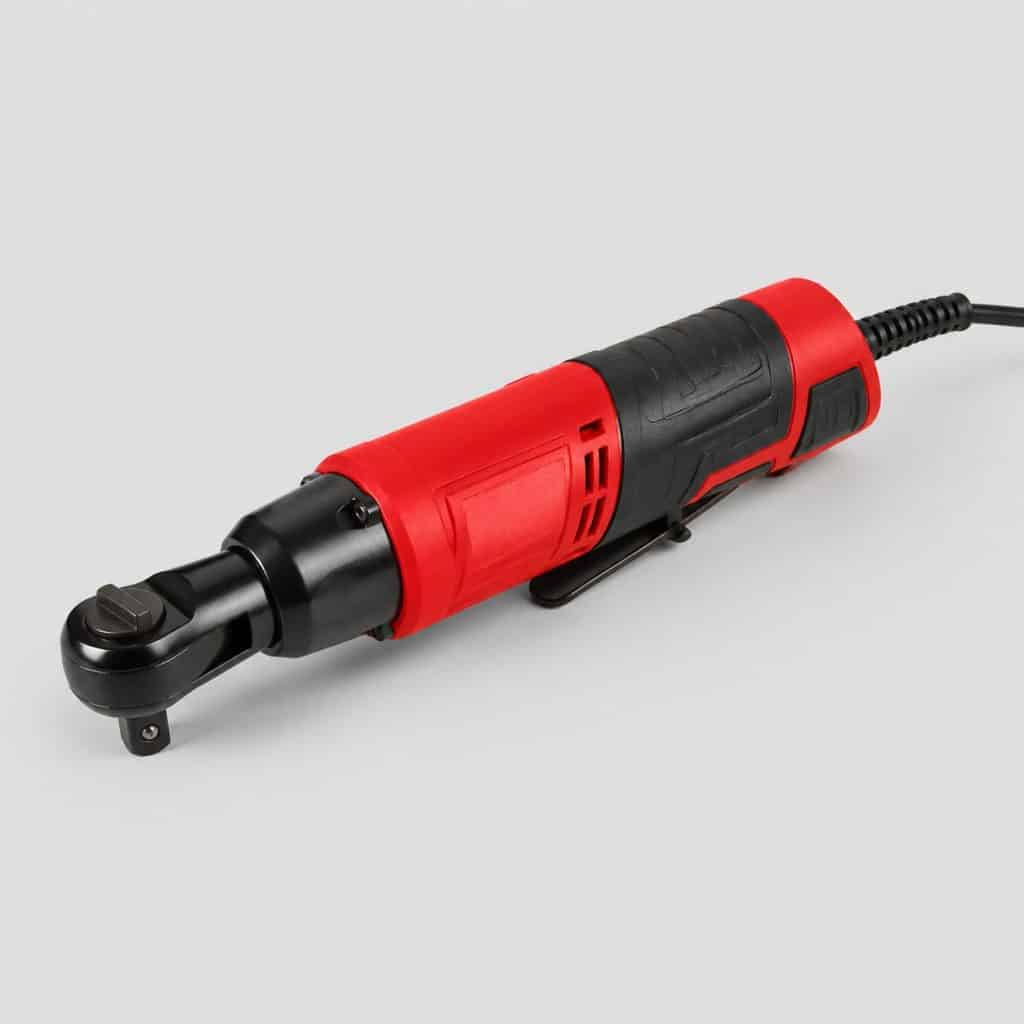 Cliquet électrique compact à coque rouge et noir avec gâchette et câble, sur fond clair