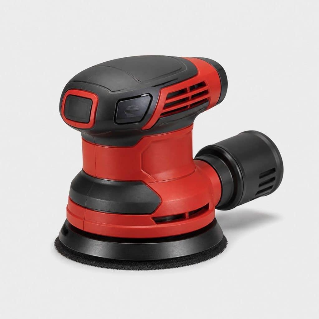 Ponceuse excentrique compacte rouge et graphite sur un établi